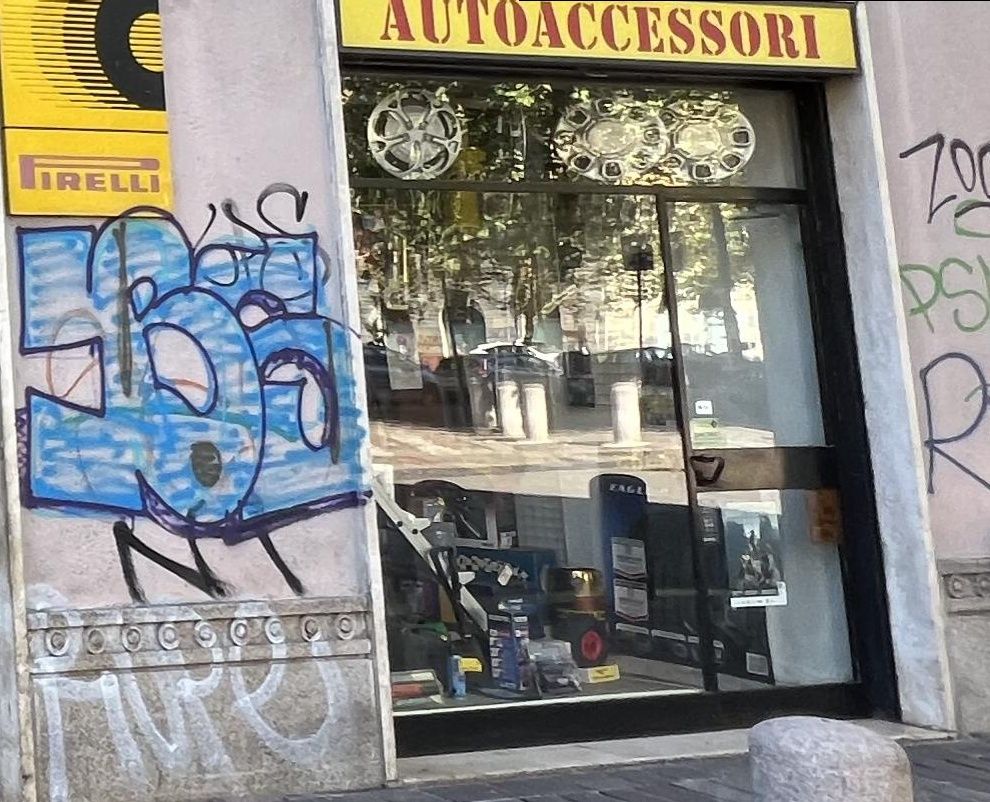 La vetrina degli accessori sull'angolo, con le coppe ruota appese in fila dietro il vetro