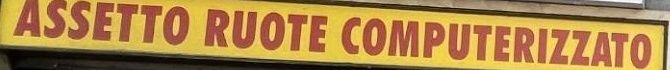Il dettaglio del banner giallo con la scritta rossa: «Assetto ruote computerizzato»